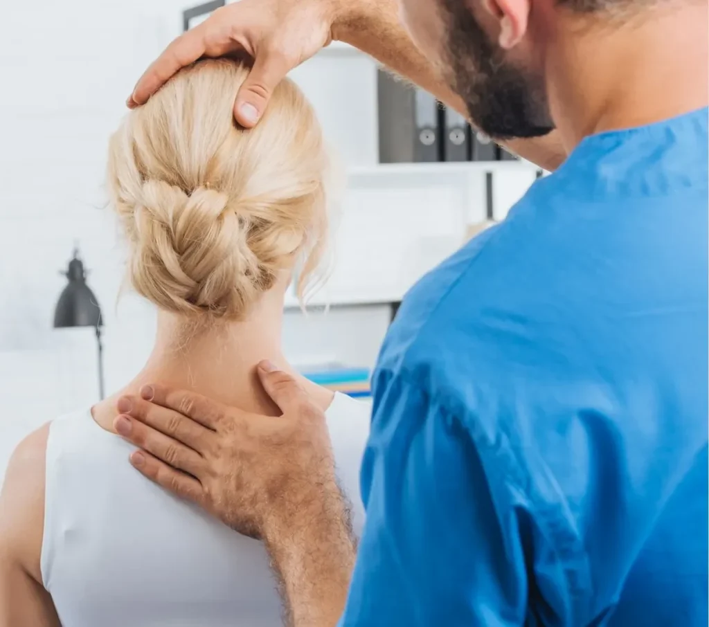 Terapeuta wykonuje terapię manualną karku pacjentki